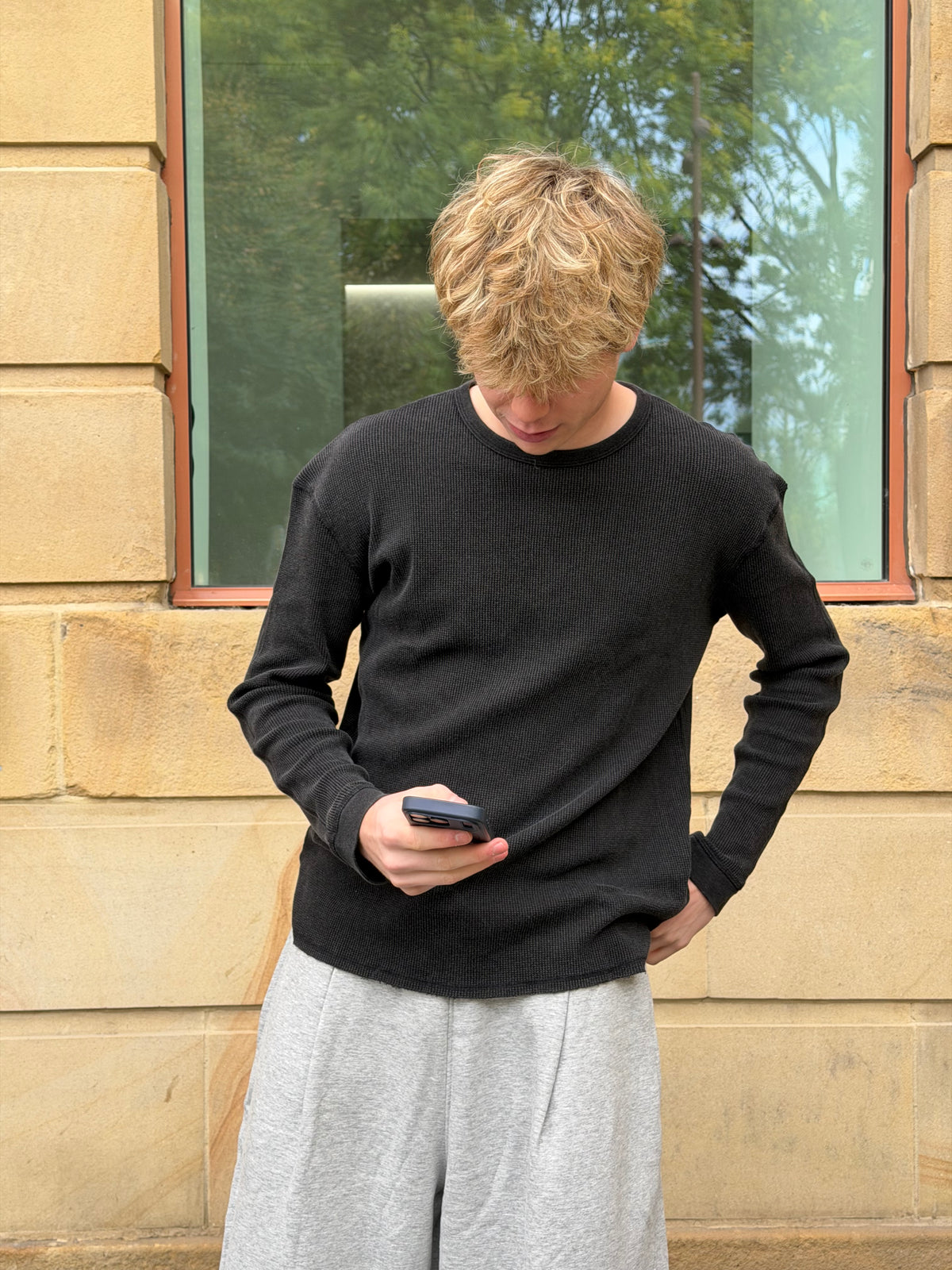 Weekday men's grey joggers styled with a black long sleeve tee.