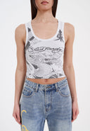 Person wearing a graphic tank top with 'Ed Hardy' branding and high-waisted jeans.