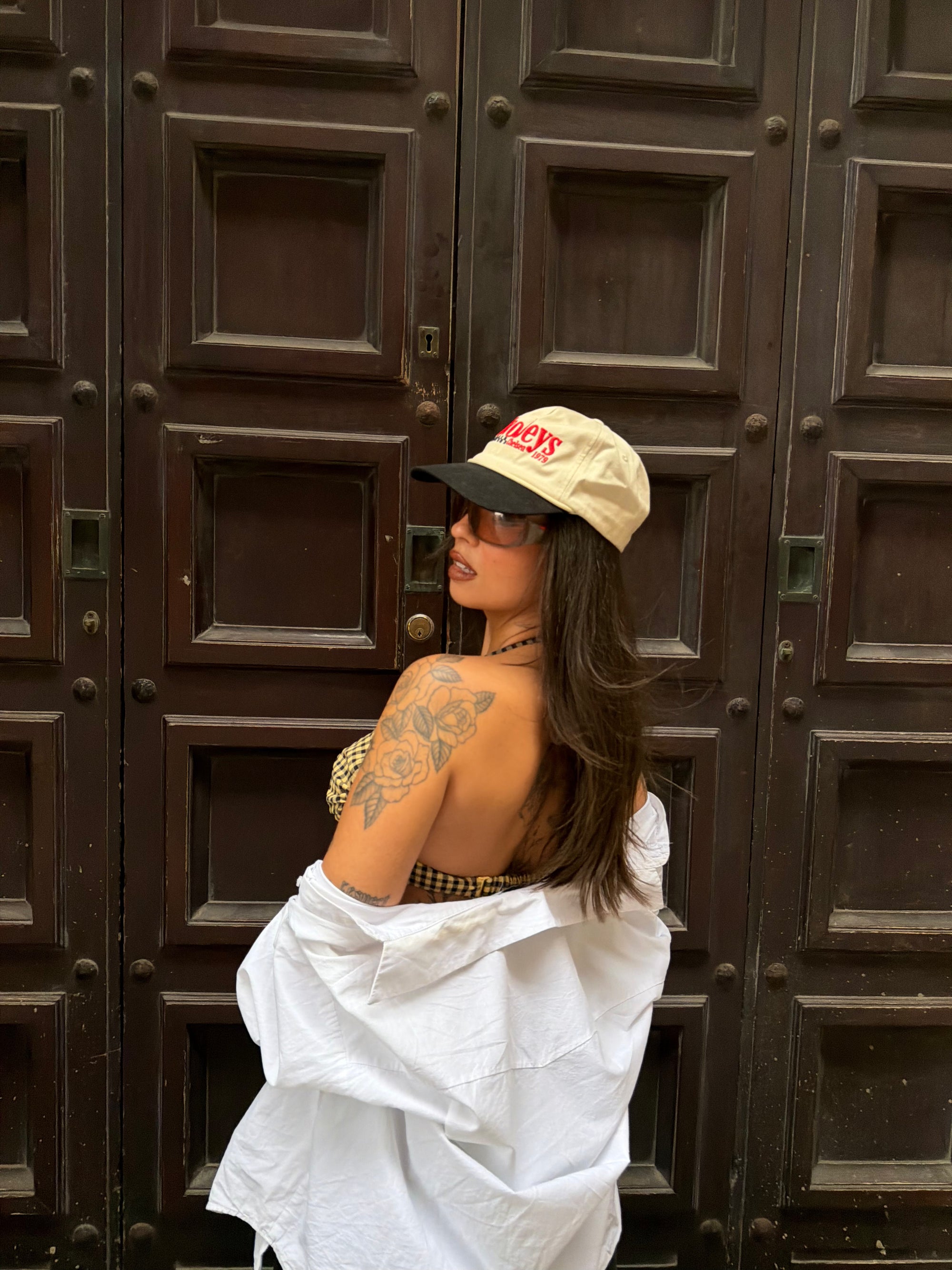 Wild Lovers Lemonade bikini styled with joggers, a white shirt, sunglasses and a cap.
