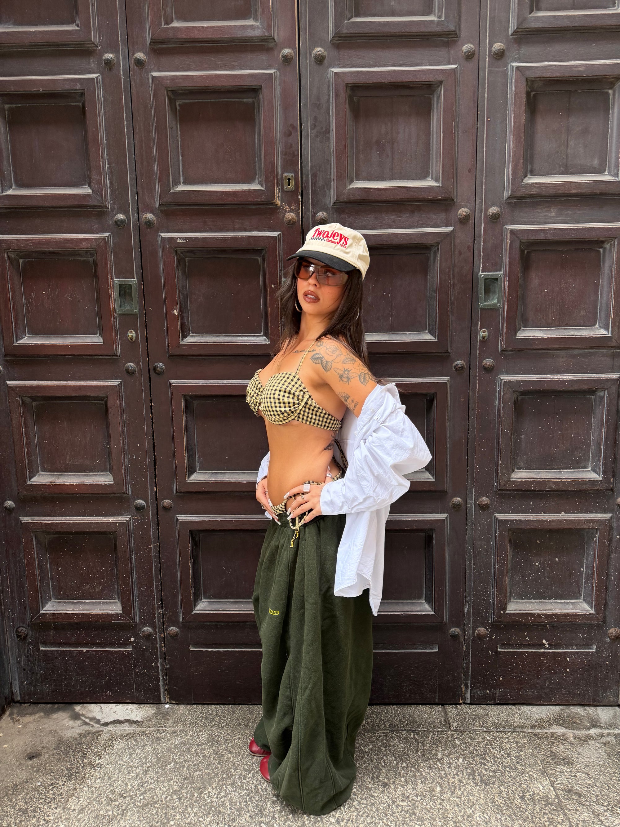 Wild Lovers Lemonade bikini styled with joggers, a white shirt, sunglasses and a cap.