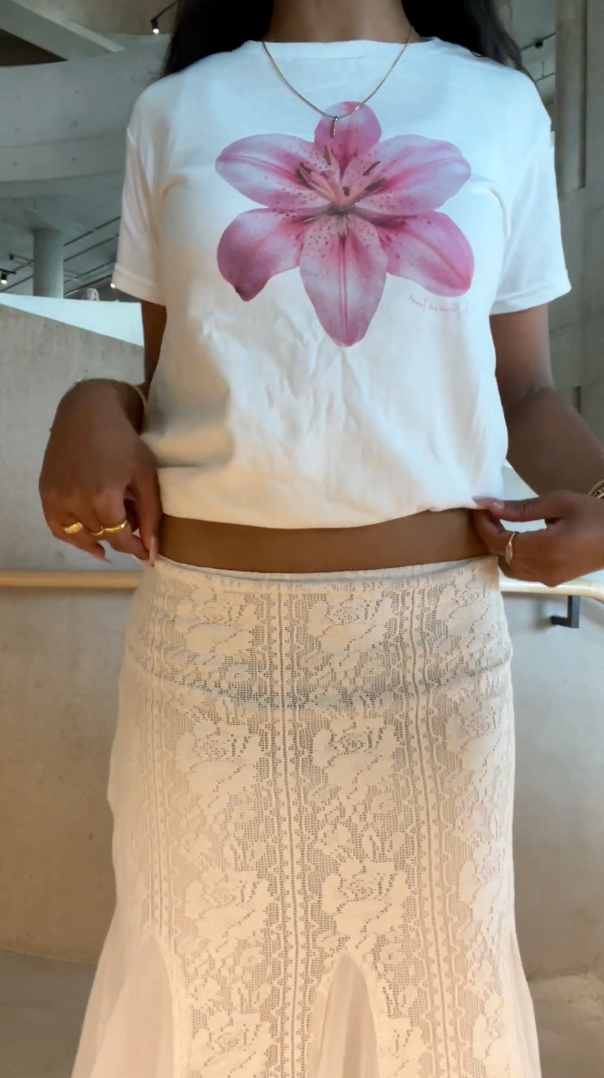 In Print We Trust graphic baby tee styled with a long white lace skirt for a relaxed summer outfit.