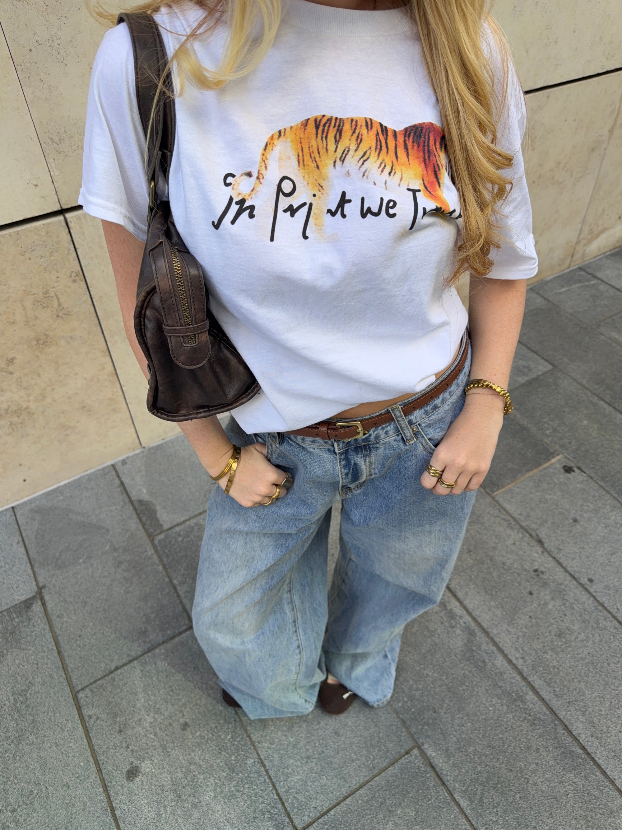In Print We Trust Tiger Classic Tee styled with blue jeans and a shoulder bag.