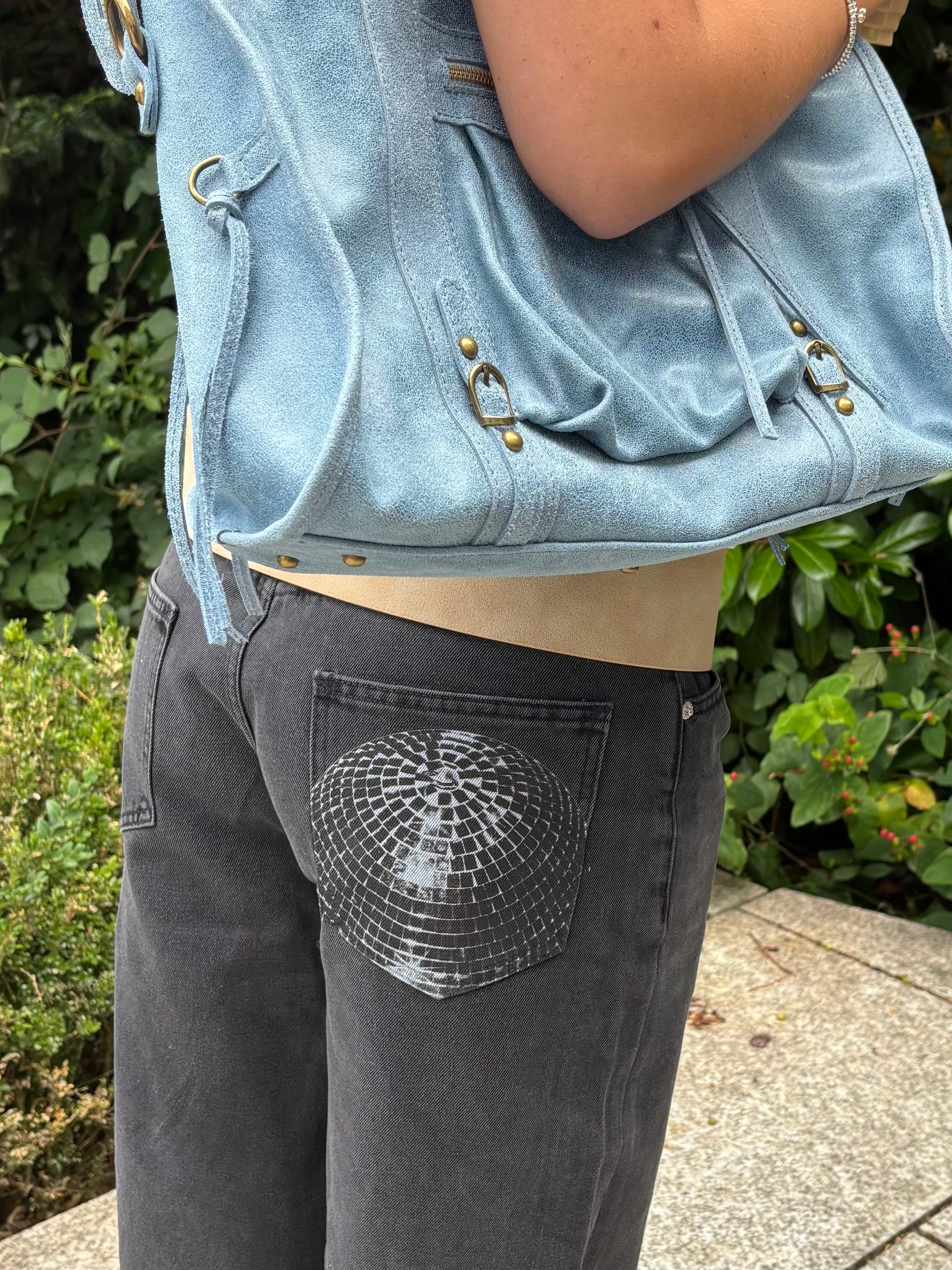White In Print We Trust After Party Baby Tee styled with black Studio 54 jeans and a blue bag.