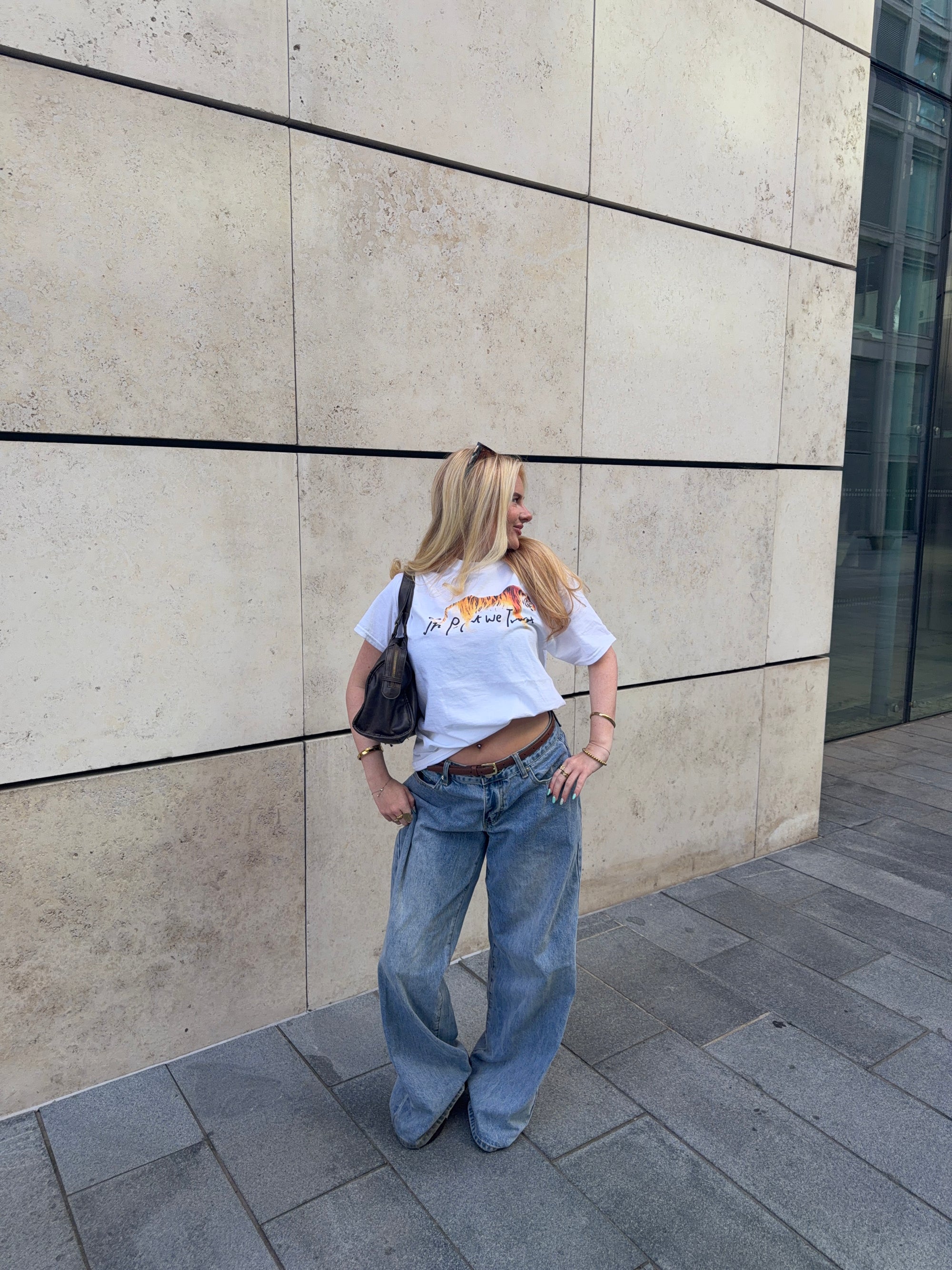 In Print We Trust Tiger Classic Tee styled with blue jeans and a shoulder bag.