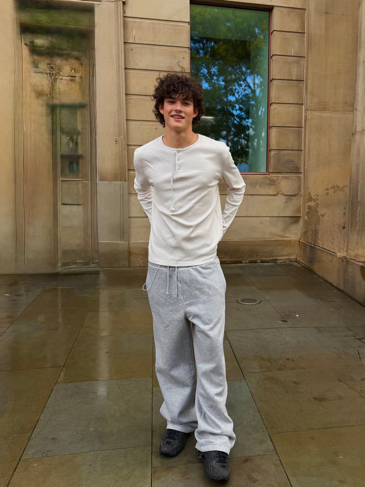 Men's white Weekday henley top styled with grey joggers.